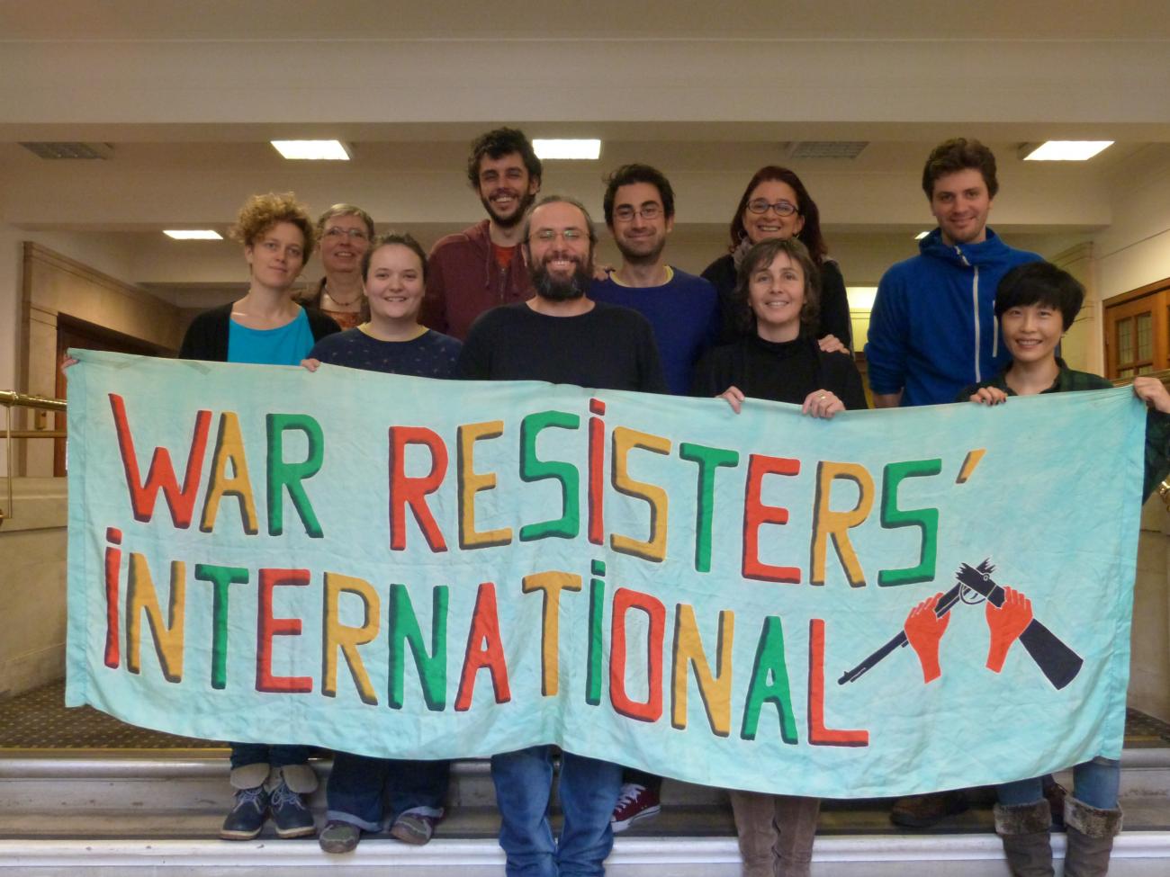 A group of people holding a banner that says War Resisters International