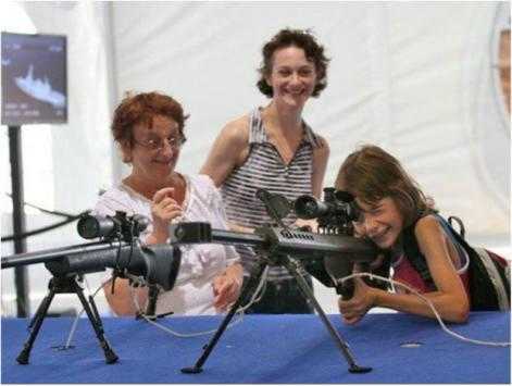 Militarised Parenting: Three generations share the joy of this child's possible future (Weapons Expo, Israel, 2008) (credit – Activestills)