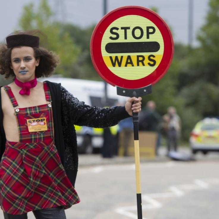 Someone blocks a road outside the DSEI arms fair with a traffic sign reading "stop wars"