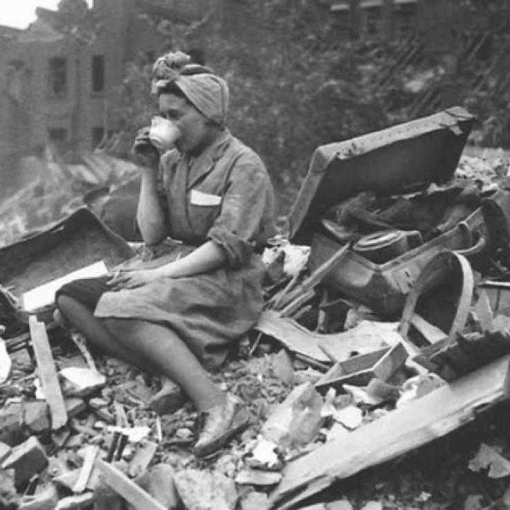 Une femme boit une tasse de thé assise sur des ruines 