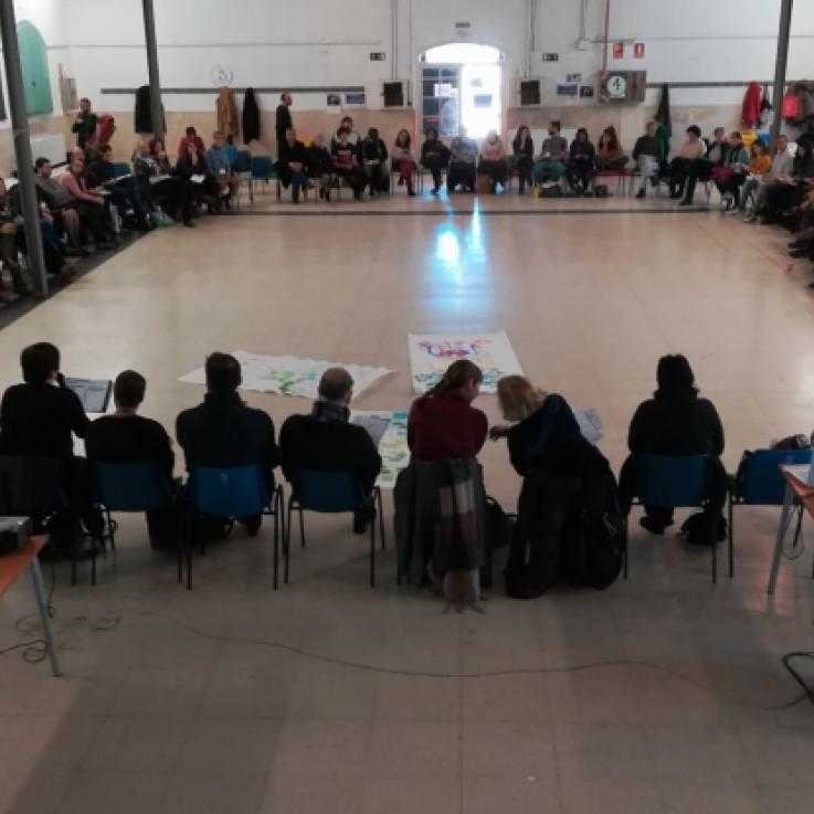 A large group of people sit in a large circle during the Noviolencia2018 congress