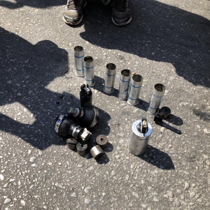 Around a dozen spent tear gas canisters and grenades displayed on the street