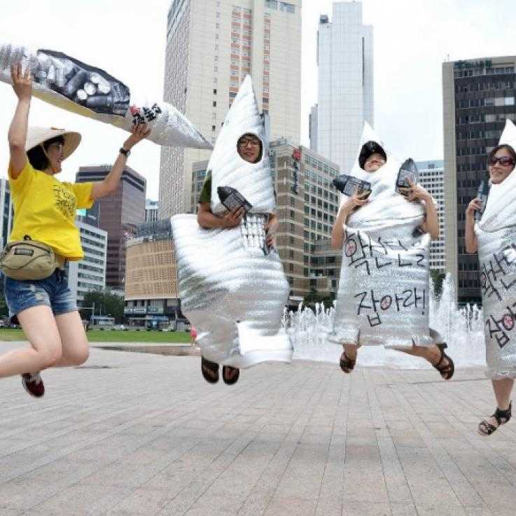 Four activists dressed as cluster munitions jump in the air
