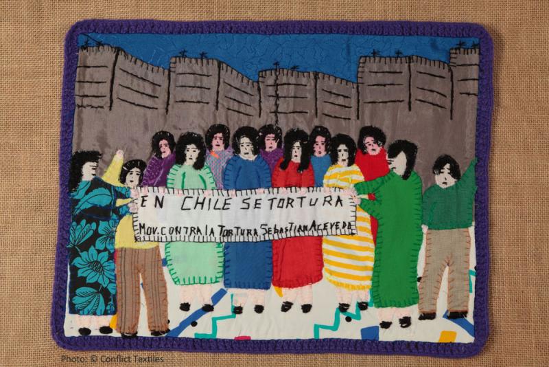 En Chile se tortura / Demonstration against torture, Chilean arpillera, Violeta Morales, 1988, Photo Martin Melaugh, Oshima Hakko Museum collection, Japan. In the care of Conflict Textiles collection