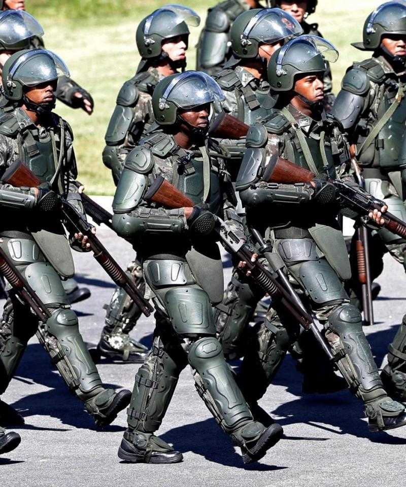 Una gran cantidad de policías fuertemente armados, con armas de fuego, marcha en Brasil