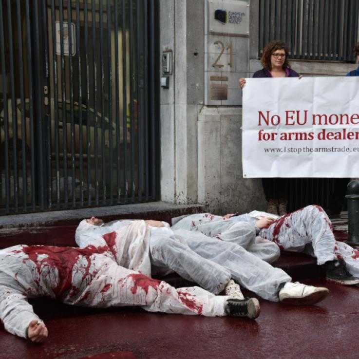 Activists in Belgium protest against the arms industries access to the EU, pouring blood on the street.