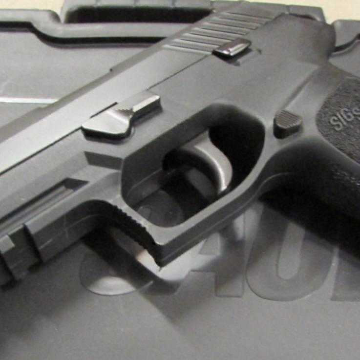 A Sig Sauer P320 pistol sat on a box