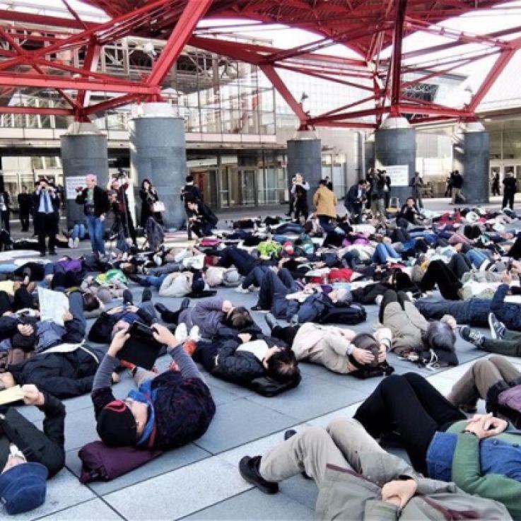 A large group of people take part in a die-in