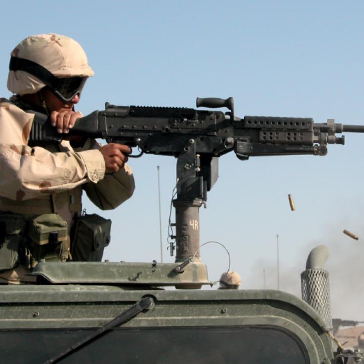 A soldier fires a vehicle mounted machine gun